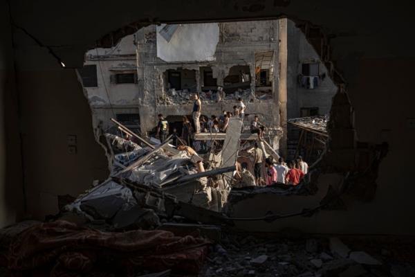 Palestinians look at the destruction after Israeli strikes on the Gaza Strip in Khan Younis, Saturday, Now. 4, 2023. (AP Photo/Fatima Shbair)