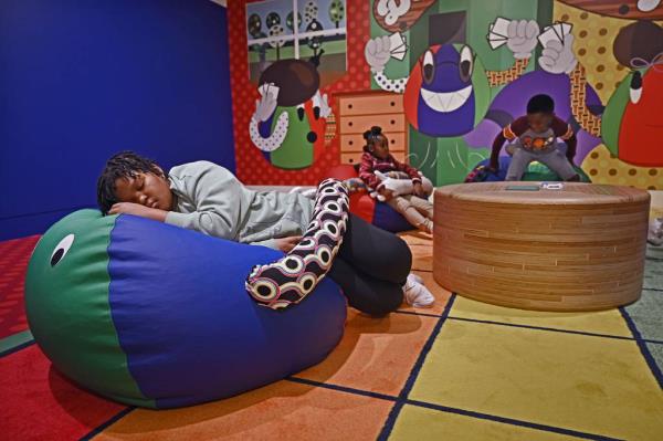 Ardyn Redmon, 8, left, and other children from Greenmount West Community Center play in the new art installation 