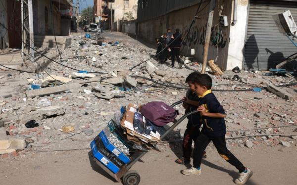 Young boys push a loaded trolley in Rafah in the southern Gaza Strip on December 10, 2023, as battles between Israel and the Palestinian Hamas movement. Israeli forces pushed into southern Gaza on December 10, wher<em></em>e hundreds of thousands of civilians have fled in search of shelter from bombardments and intense fighting with Hamas militants. (Photo by MOHAMMED ABED / AFP)