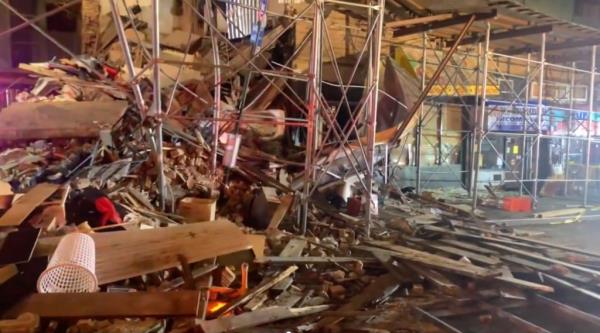 The facade of a building and a scaffolding partially collapsed exposing the apartments at 172 W Burnside Ave.