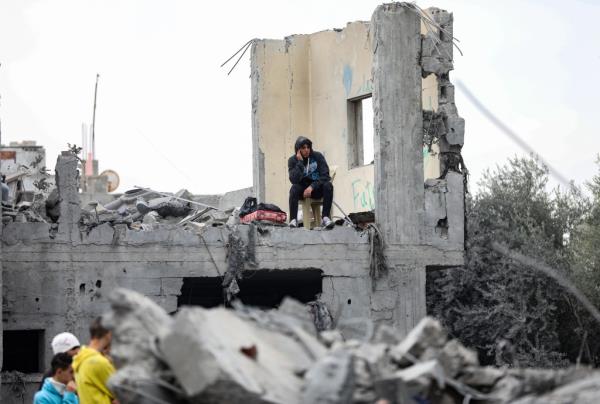 Palestinians watch over the destruction of their neighborhood in central Gaza. 