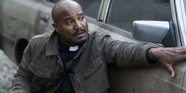 Father Gabriel hiding behind a car and surveying the scene on The Walking Dead.