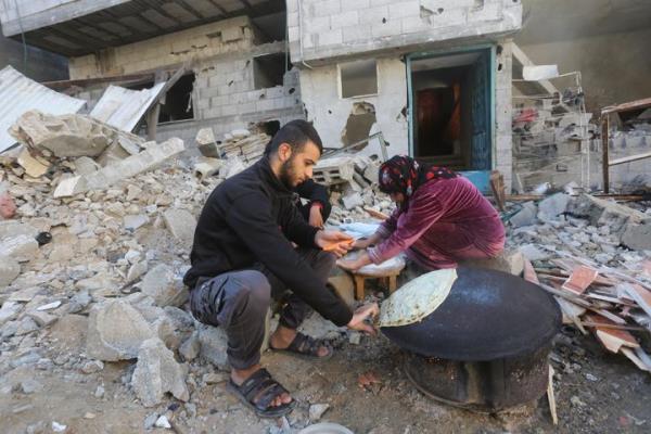 Palestinians bake bread by their destroyed homes in Kuza' a Gaza Strip during the temporary ceasefire between Hamas and Israel on Nov. 29, 2023. 