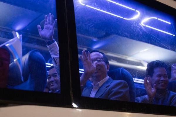 Thai natio<em></em>nals who were taken hostage by Hamas militants and recently released, wave from inside a bus as they leave the Shamir Medical Center near the city of Ramla, heading toward the airport to be flown home, on November 29, 2023. (Photo by Oren ZIV / AFP) (Photo by OREN ZIV/AFP via Getty Images)