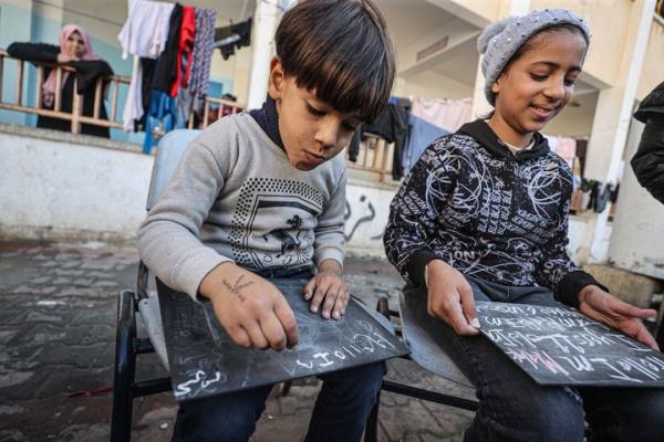 RAFAH, GAZA - NOVEMBER 29: 25-year-old Palestinian English teacher Tariq al-Annabi co<em></em>ntinues to afford teaching English to children who took refuge with their families at Taha Hussein School after Israeli attacks following the extension of the 'humanitarian pause' in Rafah, Gaza on November 29, 2023. (Photo by Mustafa Hassona/Anadolu via Getty Images)