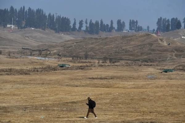 A man walks through an area in Kashmir wher<em></em>e low snowfall is causing co<em></em>ncern as the region’s eco<em></em>nomy is highly dependent on it. Credit: Umar Manzoor Shah/IPS