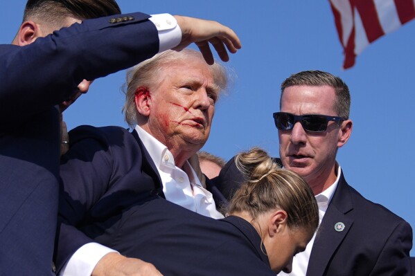 Republican presidential candidate former President Do<em></em>nald Trump is surrounded by U.S. Secret Service agents as he leaves the stage at a campaign rally, Saturday, July 13, 2024, in Butler, Pa. (AP Photo/Evan Vucci)