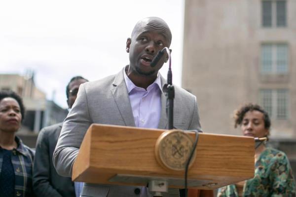 Council Member Kevin C. Riley speaking into a microphone at New York City Council meeting