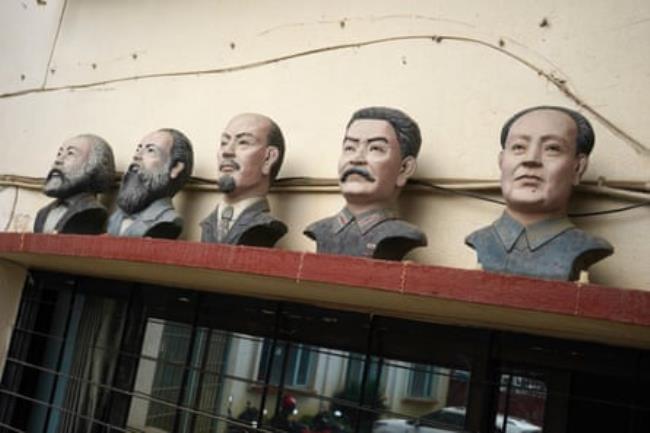 A row of five painted busts of men on the outside a building