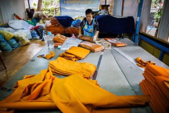 A woman packing the orange robes made from recycled plastic at Wat Chak Daeng in Bangkok.