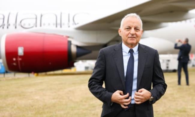 Tufan Erginbilgiç standing in front of a Virgin Atlantic jet in a field at Farnborough airshow