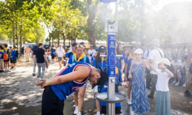 Tourists take advantage of a water-point to cool off.