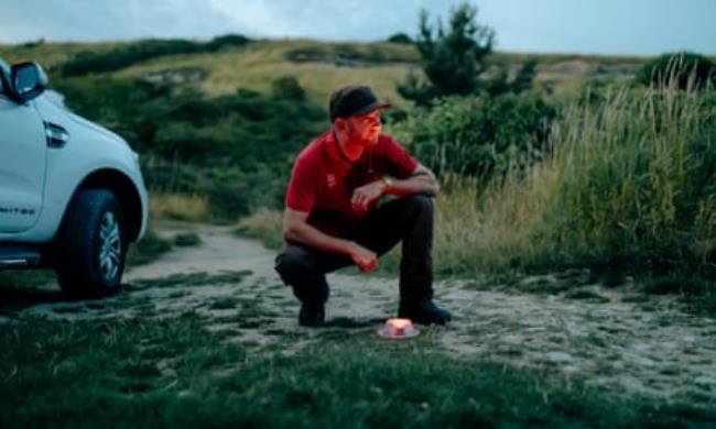 Ben Cooke places his glow-worm trap co<em></em>nsisting of a red light under a plastic cup.