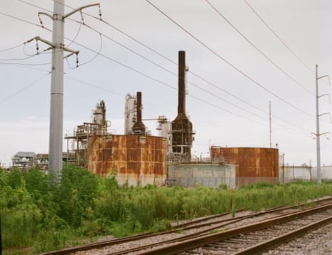 An industrial facility sits next to a railway.