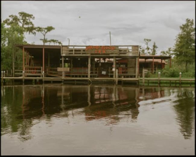 A drinking establishment on a dock on the shore of a body of water.