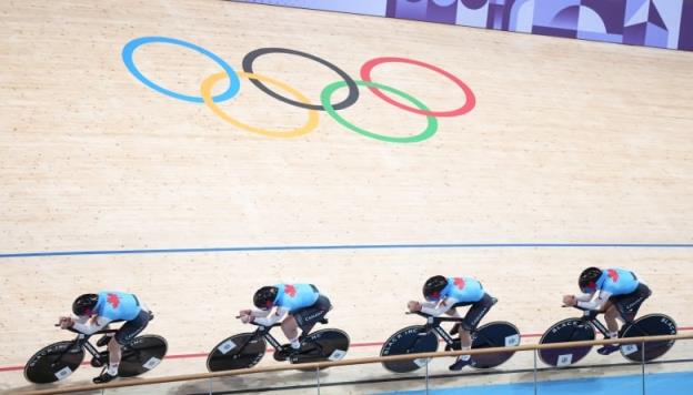 Four women cycle on a track. 