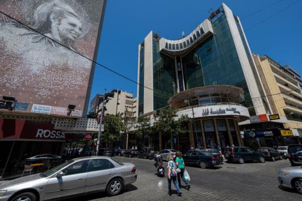 People walk past a mural bearing a portrait of Lebanon's late ico<em></em>nic singer Sabah in the heart of Beirut's Hamra shopping district