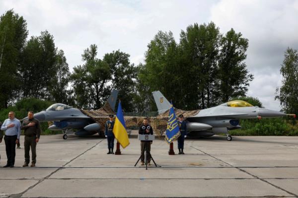 Ukraine's President Volodymyr Zelenskiy signs a natio<em></em>nal anthem next to F-16 fighting aircrafts during marking the Day of the Ukrainian Air Forces, amid Russia's attack on Ukraine, in an undisclosed location, Ukraine August 4, 2024. REUTERS/Valentyn Ogirenko