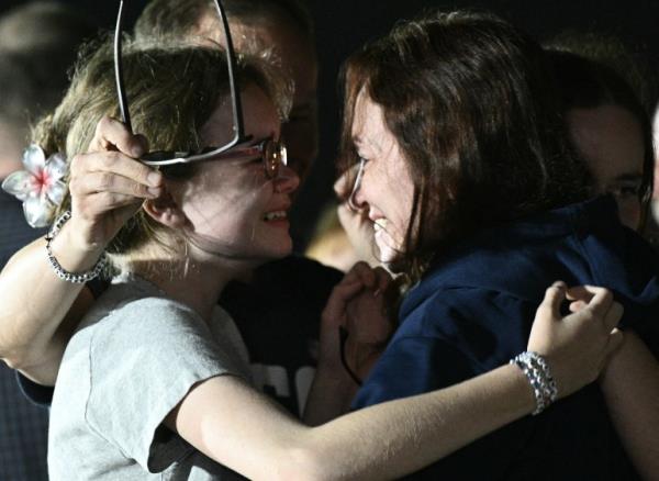 Journalist Alsu Kurmasheva embraces her daughters at the airport. They look really happy