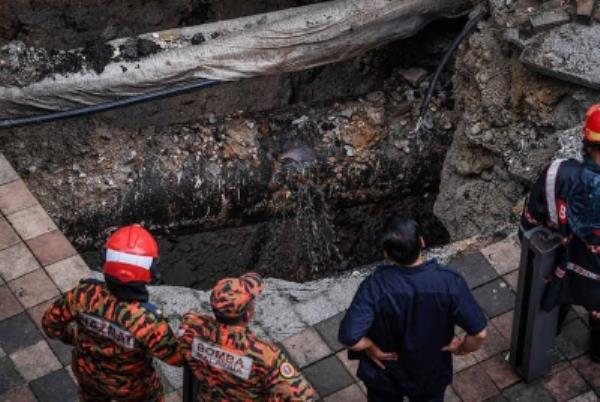 Members of the Malaysian Fire and Rescue Department and the Malaysian Civil Defence Force actively working to rescue the victim.