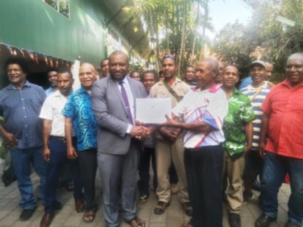 The chairman of Kodu Resource Owners Association, Sam Dabave, (right) presents the petition to Andy Hetra, the PNG prime minister’s chief of staff, who received the petition on behalf of PM James Marape in Port Moresby on Friday.