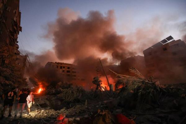 Smoke rises from the smouldering rubble as people gather at the scene of Israeli air strikes in the Haret Hreik neighbourhood of Beirut's southern suburbs on September 27, 2024.