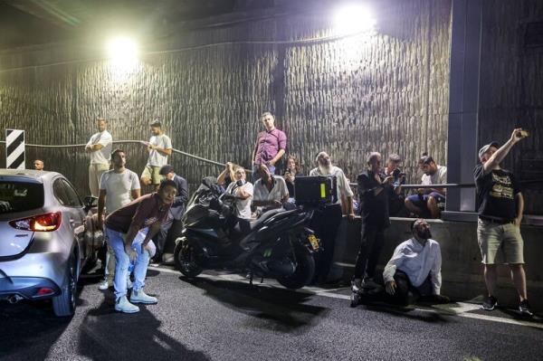 People take cover under a bridge along the side of a highway in Tel Aviv on October 1, 2024. Air raid sirens sounded in central Israel on October 1, the military said, a day after the army launched ground operations into southern Lebanon targeting Hezbollah positions. 