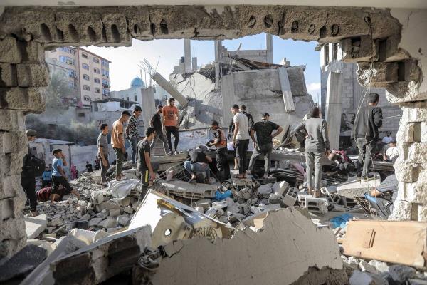 People search buildings destroyed during airstrikes on November 18, 2023 in Khan Yunis, Gaza.