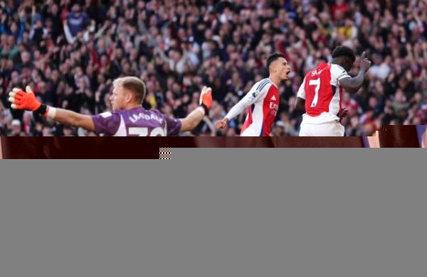 Arsenal’s Bukayo Saka runs away to celebrate as Aaron Ramsdale gestures with his arms