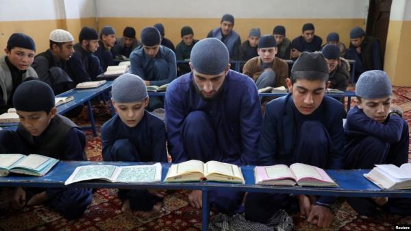 FILE - Afghan boys read the Quran in a madrassa, or religious school, during the Muslim holy mo<em></em>nth of Ramadan in Kabul, Afghanistan, April 18, 2021. The number of madrassas has grown fourfold in Afghanistan since the Taliban seized power in 2021.