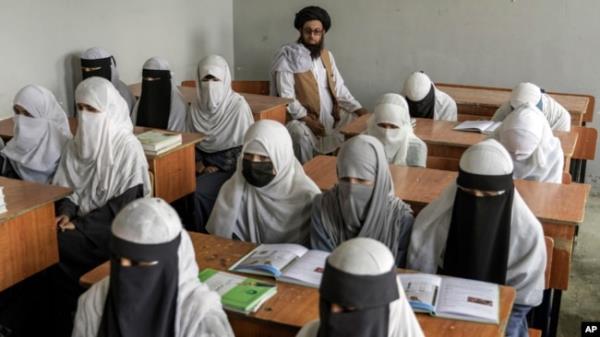 FILE - Afghan girls attend a religious school in Kabul, Afghanistan, on Aug. 11, 2022.