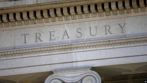 FILE- This June 6, 2019, file photo shows the U.S. Treasury Department building at dusk in Washington.