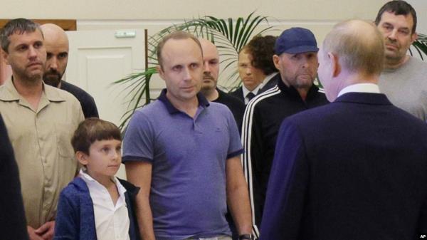 A man identified as Pablo Gonzalez, a freelance journalist from Spain, second from left with shaved head, listens to Russian President Vladimir Putin, back to a camera, speaking to released Russian priso<em></em>ners on Thursday, Aug. 1, 2024.