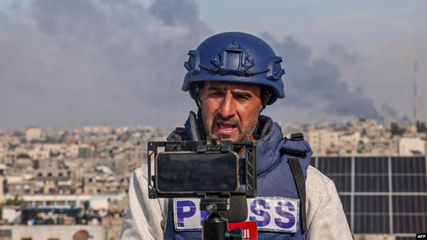 FILE - A Palestinian journalist uses his mobile phone to broadcast live in Rafah on the southern Gaza Strip, Dec. 27, 2023, amid battles between Israel and Hamas.