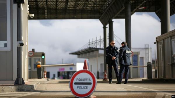 FILE - Kosovo police officers stand at the closed Merdare border crossing between Kosovo and Serbia, Dec. 28, 2022. 