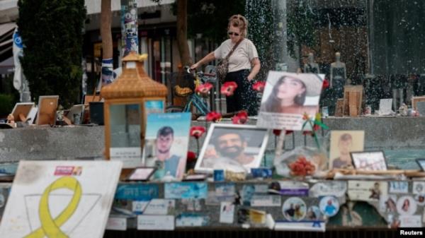 FILE - A woman looks at pictures of hostages kidnapped during the deadly October 7 attack on Israel by Hamas, one year after the attack, in Tel Aviv, Oct. 7, 2024.