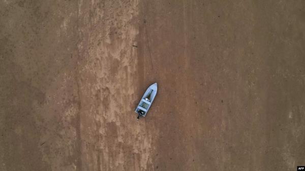 FILE - A boat is seen stranded on the dry riverbed of the Pahang river in Chenor, Malaysia's Pahang state, Aug. 10, 2023.