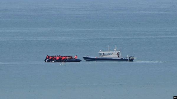 FILE - A boat thought to be carrying migrants is escorted by a vessel from the French Gendarmerie Natio<em></em>nale in the English Channel off Wimereux beach, France, Sept. 4, 2024. 