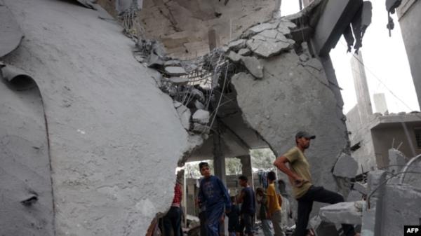 Palestinians check the rubble of a mosque-turned-shelter in Deir al-Balah in the central Gaza Strip, targeted by an Israeli strike during the night of Oct. 6, 2024.