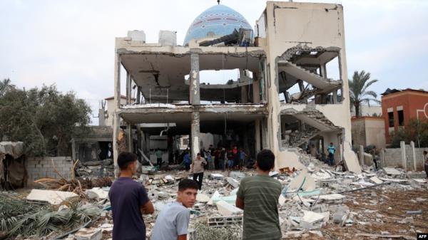 Palestinian stare at a mosque-turned-shelter in Deir al-Balah in the central Gaza Strip, heavily damaged in an Israeli strike during the night of Oct. 6, 2024. 