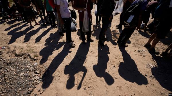 FILE - Migrants wait to be processed by authorities after entering the US from Mexico, Oct. 19, 2023, in Eagle Pass, Texas. 