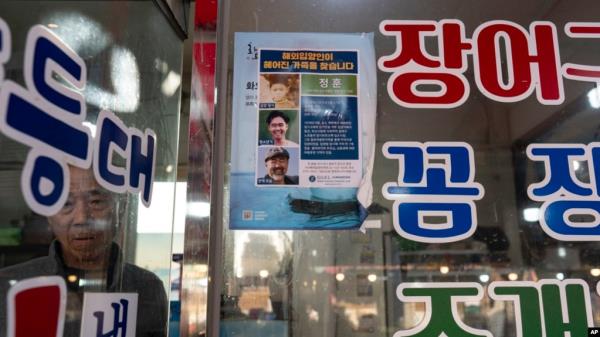 FILE - Restaurant owner Shin Byung-chul looks from behind a flyer he put up of Kenneth Barthel, who was abando<em></em>ned in the area as a child and later adopted to Hawaii at 6 years old, at his restaurant in Busan, South Korea, May 17, 2024.