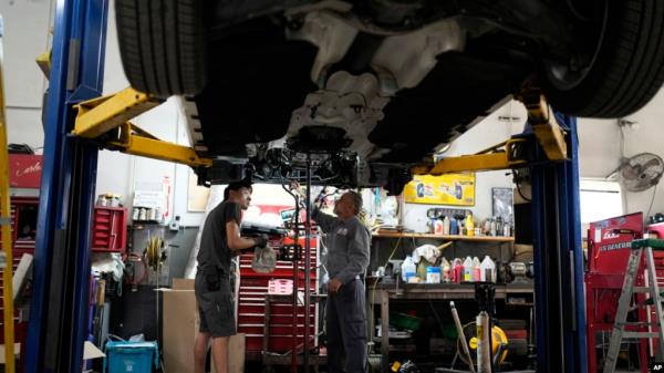 FILE - Auto mechanics work on a vehicle at the Express Auto Service Inc., in Chicago, Sept. 19, 2024. U.S. employers added 254,000 jobs in September.