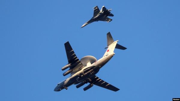 FILE - A Russian air force Beriev A-50 early-warning aircraft, with a Sukhoi Su-27 jet fighter, flies in Kaliningrad, Russia, April 25, 2020.