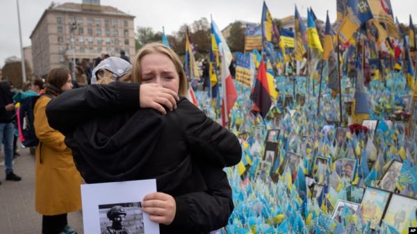 People react during a natio<em></em>nwide minute of silence in memory of fallen soldiers who defended their homeland in war with Russia, on Defenders Day at the improvised war memorial in Independence square in Kyiv, Ukraine, Oct. 1, 2024. 