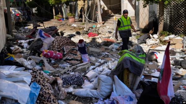 A Hezbollah paramedic walks between debris after an airstrike hit an apartment in a multistory building, in central Beirut, Lebanon, Oct. 3, 2024.