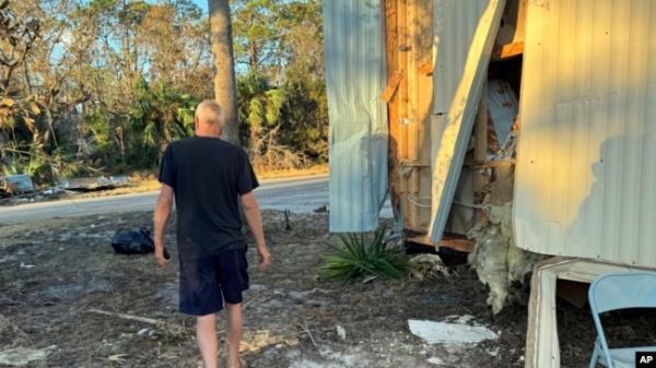 Dave Beamer walks past the partially destroyed trailer he's been living in, Sept. 29, 2024, in Steinhatchee, Florida, after Hurricane Helene washed his home into a marsh.