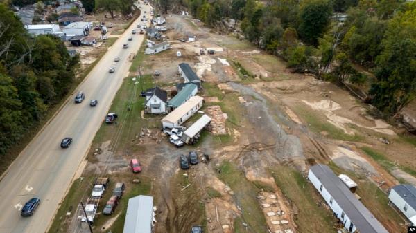 Homes and vehicles that were damaged in a flash flood from Hurricane Helene lie on the side of a road near the Swannanoa River, in Swannanoa, North Carolina, Oct. 1, 2024. 