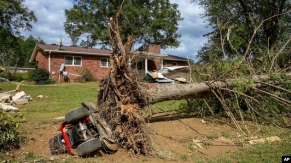 An overturned tractor lies next to an uprooted tree on the White family' property in the aftermath of Hurricane Helene, in Morganton, North Carolina, Oct. 1, 2024.