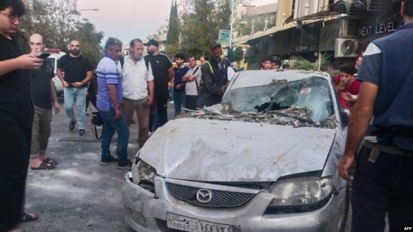 Emergency service perso<em></em>nnel and residents gather at the site of an Israeli strike in Syria's capital Damascus on Oct. 2, 2024. 